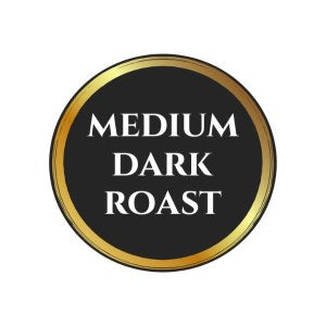 Circular label with a black background and gold border displaying the words 'Medium Dark Roast' in bold white text.