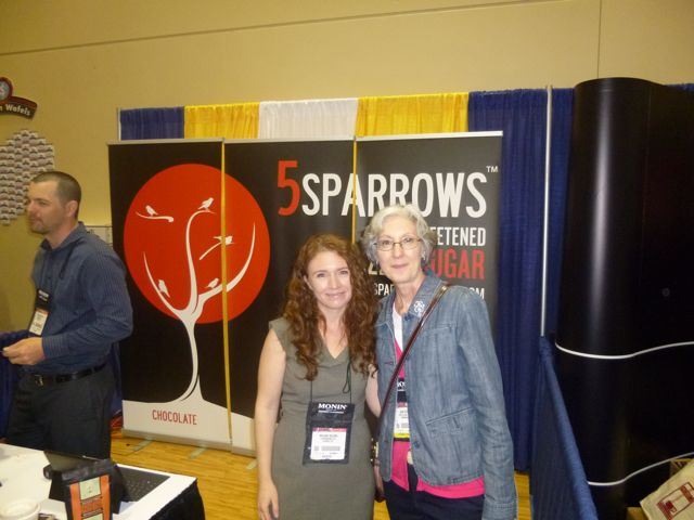 Melanie (5 Sparrows Brand) and Joan (Vista Clara Coffee) in front of the 5 Sparrows booth.